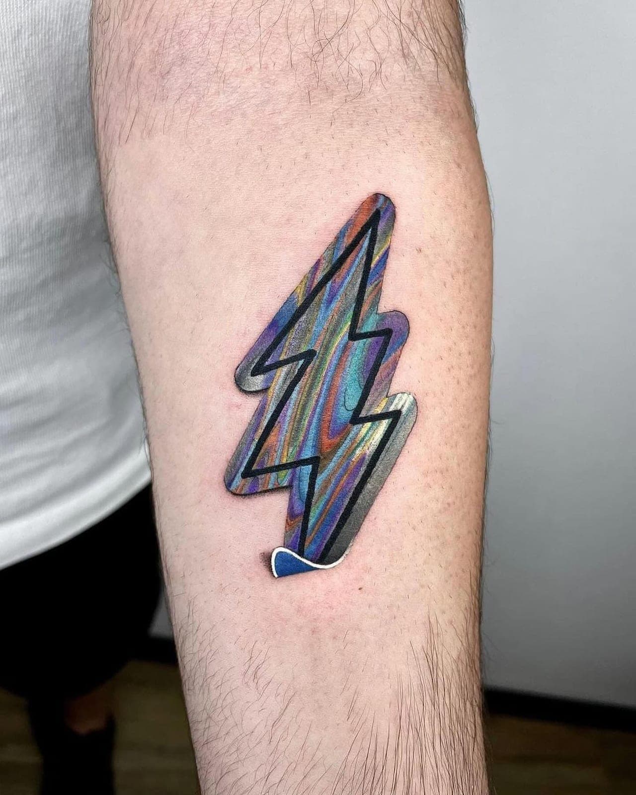 Holographic lightning bolt patch tattoo on the forearm
