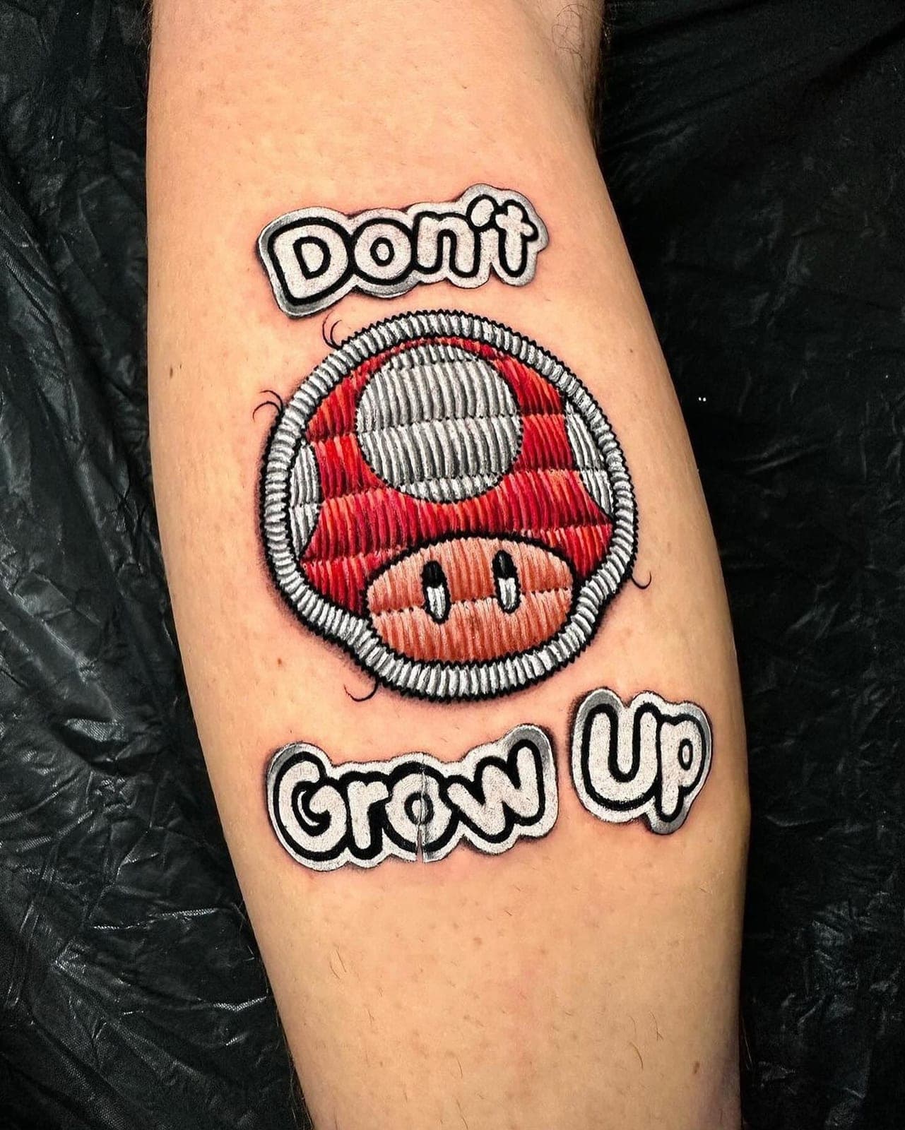 Patch tattoo of a red mushroom with the words Don't Grow Up