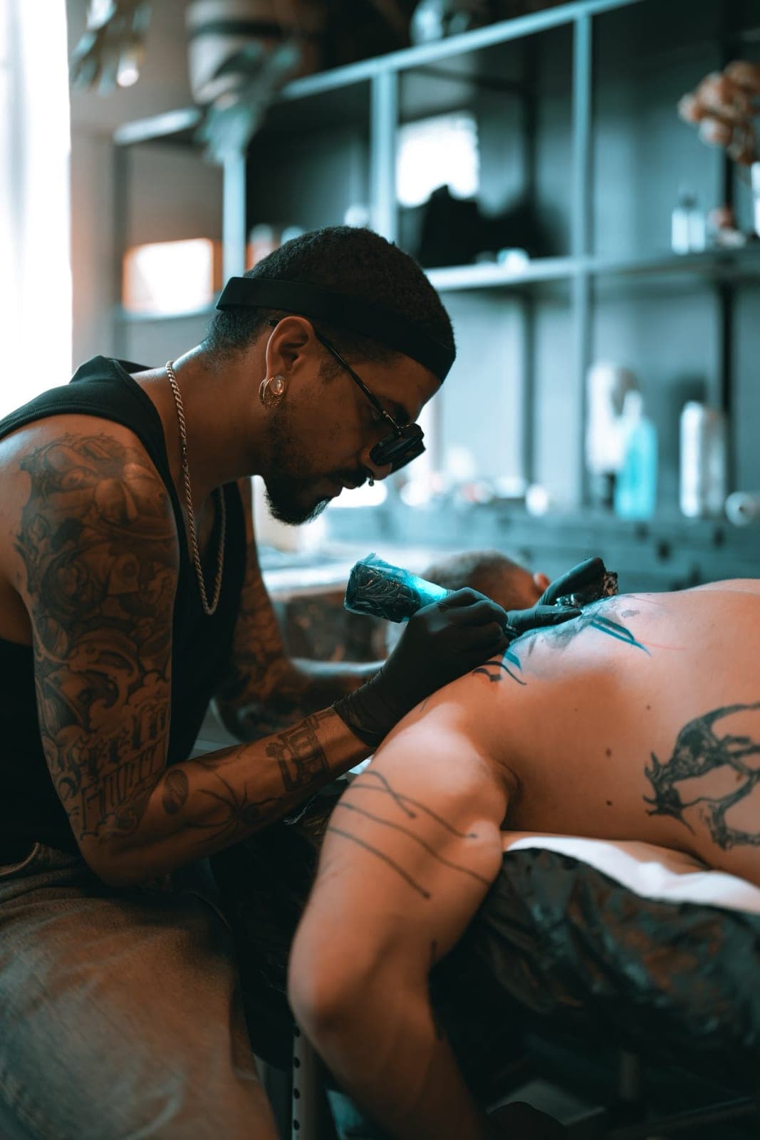 Rodmaz tattooing calligraphy on a client's back in the studio
