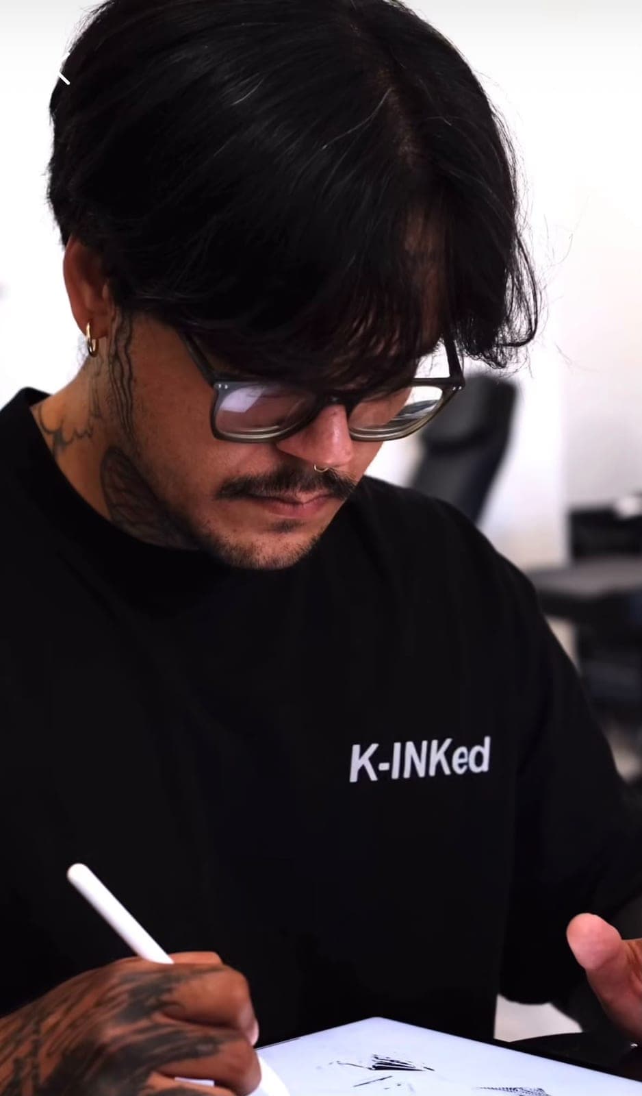 Toni Xavier drawing a design on a tablet in his studio