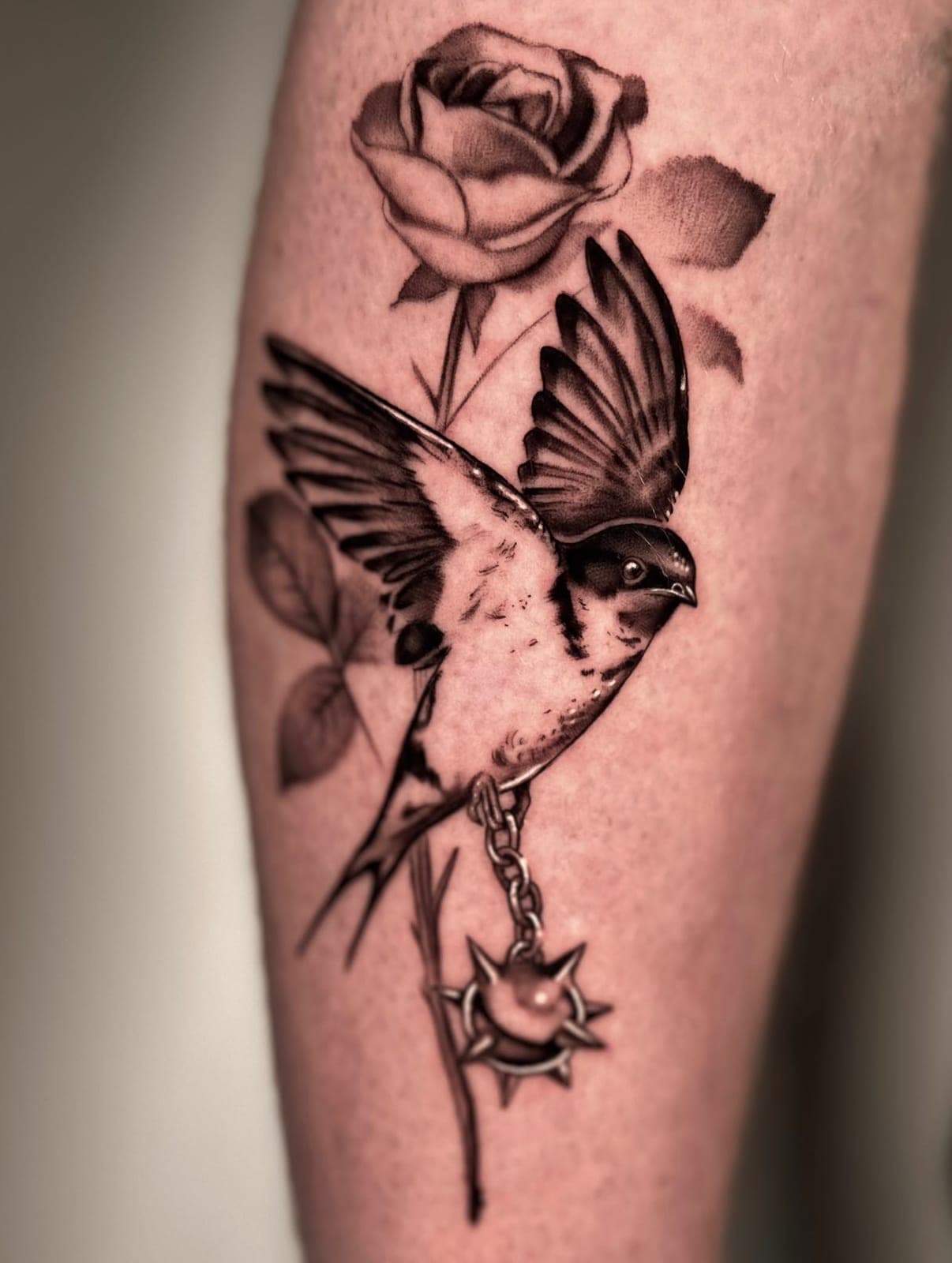 Swallow and rose tattoo on the forearm
