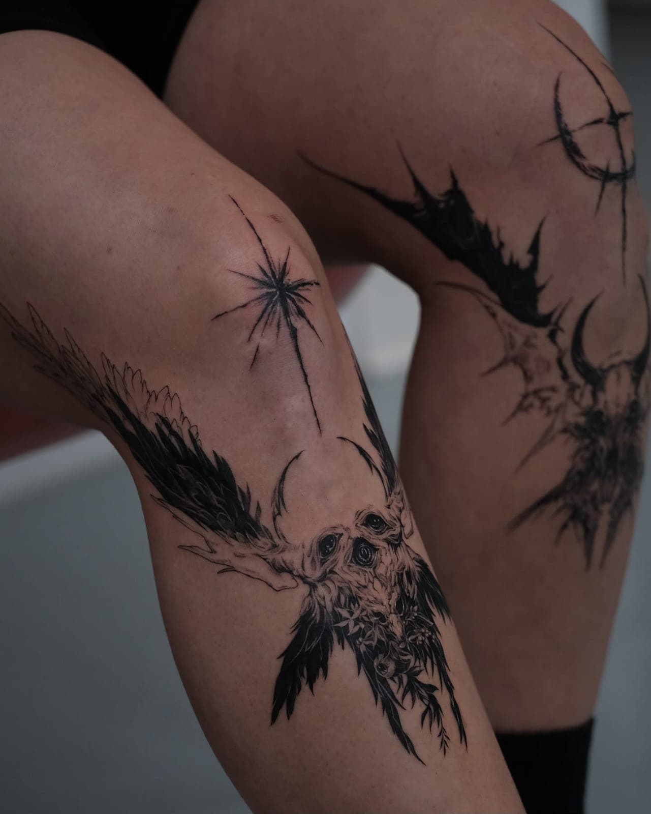 Blackwork skull with wings and a star on the knee