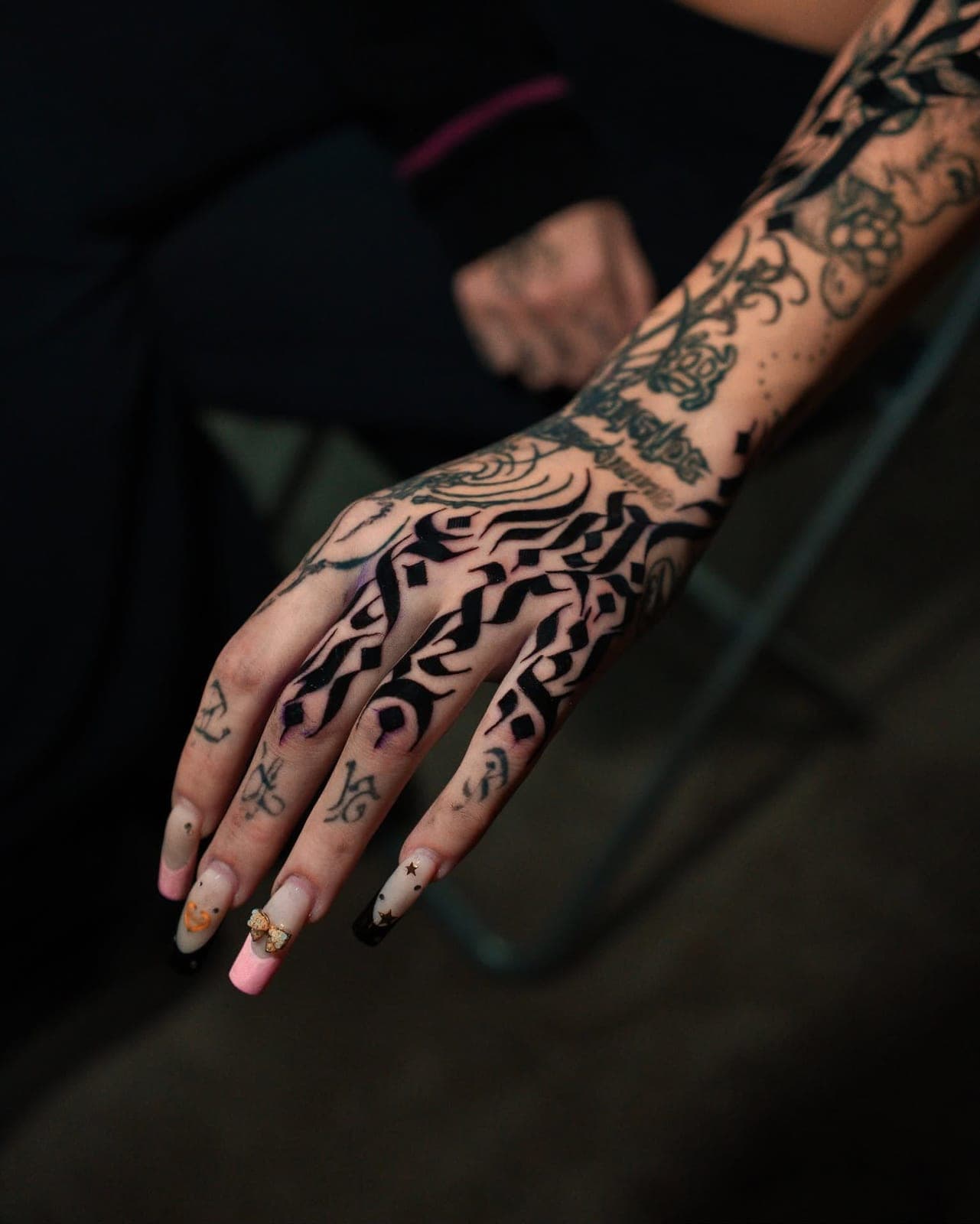 Calligraphy tattoo covering a hand and forearm